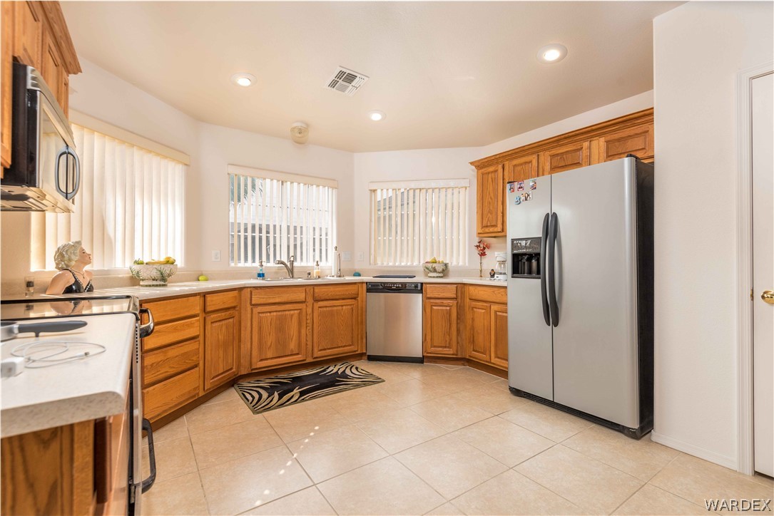 4305 East Cane Ranch Road Kingman, AZ 86401 - Photo 4 of 38 a kitchen with a refrigerator and windows