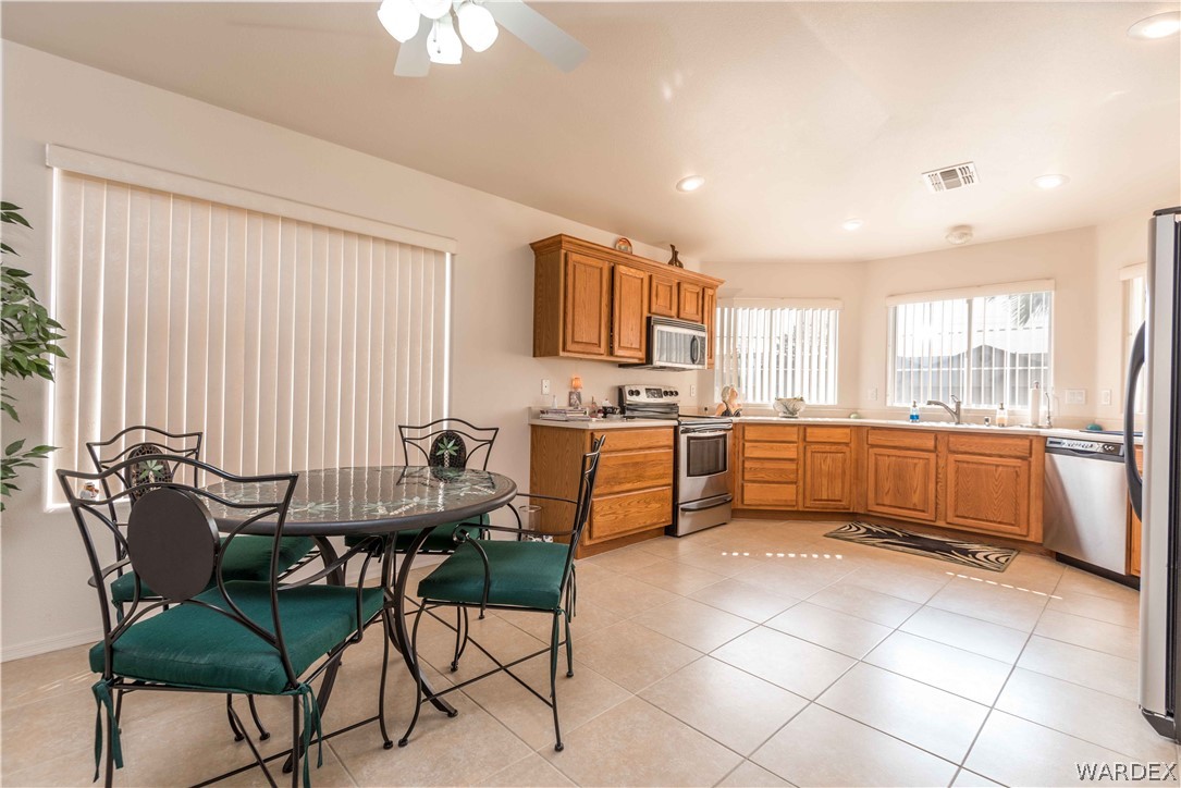 4305 East Cane Ranch Road Kingman, AZ 86401 - Photo 7 of 38 a kitchen with a dining table chairs and white appliances