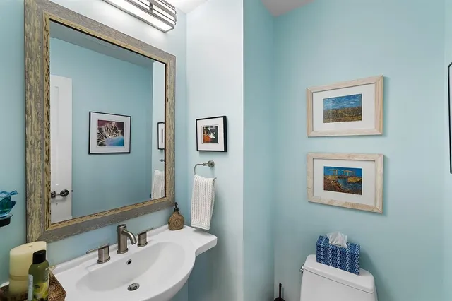 a bathroom with a sink mirror and a toilet