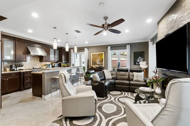 a living room with furniture kitchen and a flat screen tv