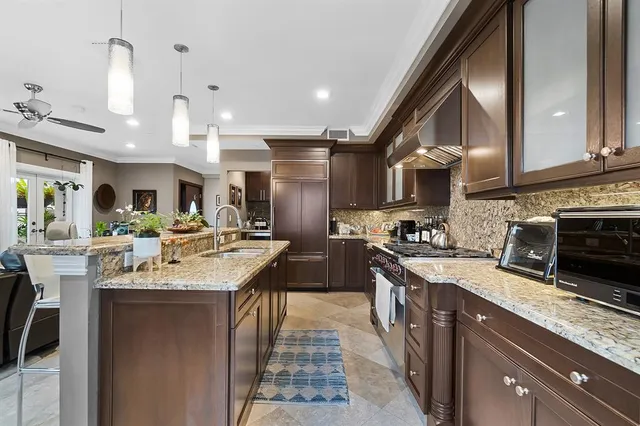 a kitchen with stainless steel appliances granite countertop a sink a stove and a wooden floors