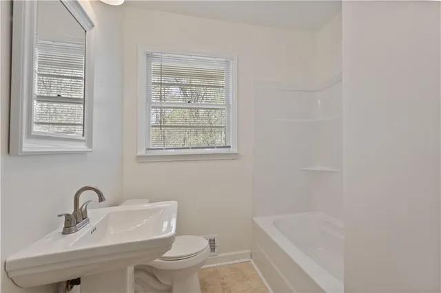 a bathroom with a sink a toilet and bathtub