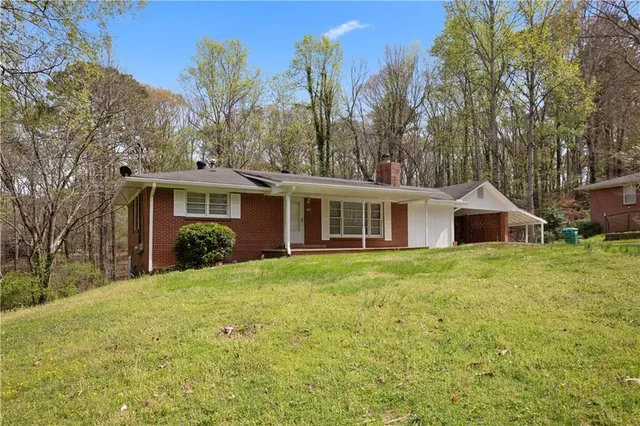 a front view of a house with a yard and trees
