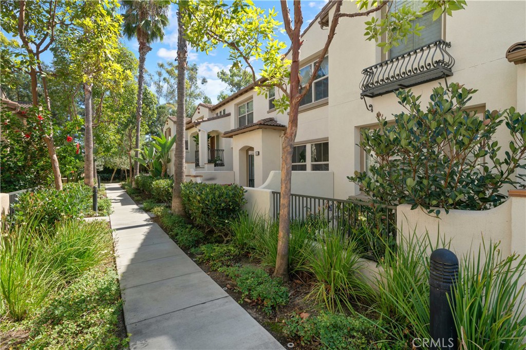 a view of a house with a small yard and large trees