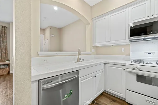 a kitchen with white cabinets and white appliances