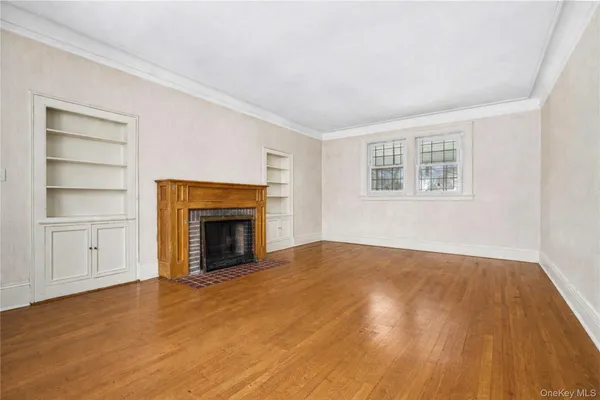 a view of an empty room with a fireplace and a window