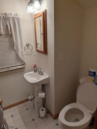 a bathroom with a toilet a sink and mirror