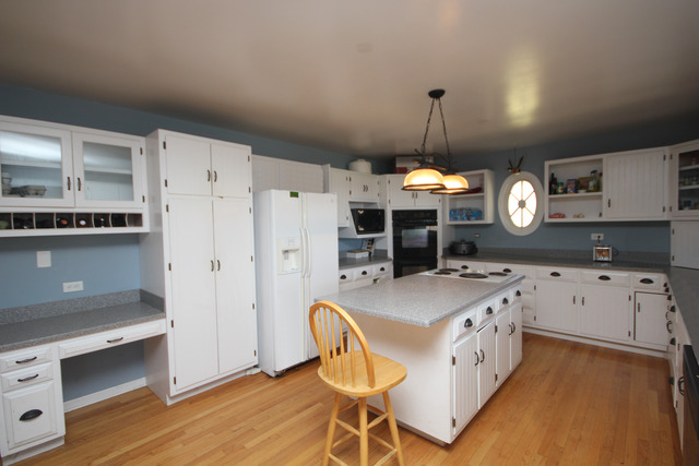 9-n301 Percy Road Maple Park, IL 60151 - Photo 9 of 25 a kitchen that has a cabinets a stove a table and chairs in it