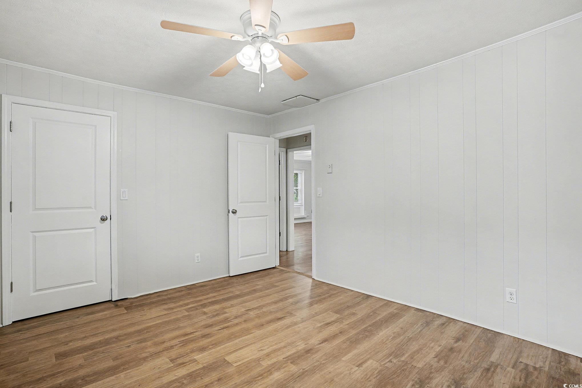 603 Maple Street Myrtle Beach, SC 29577 - Photo 14 of 40 Empty room featuring wood finished floors, crown molding, and a ceiling fan