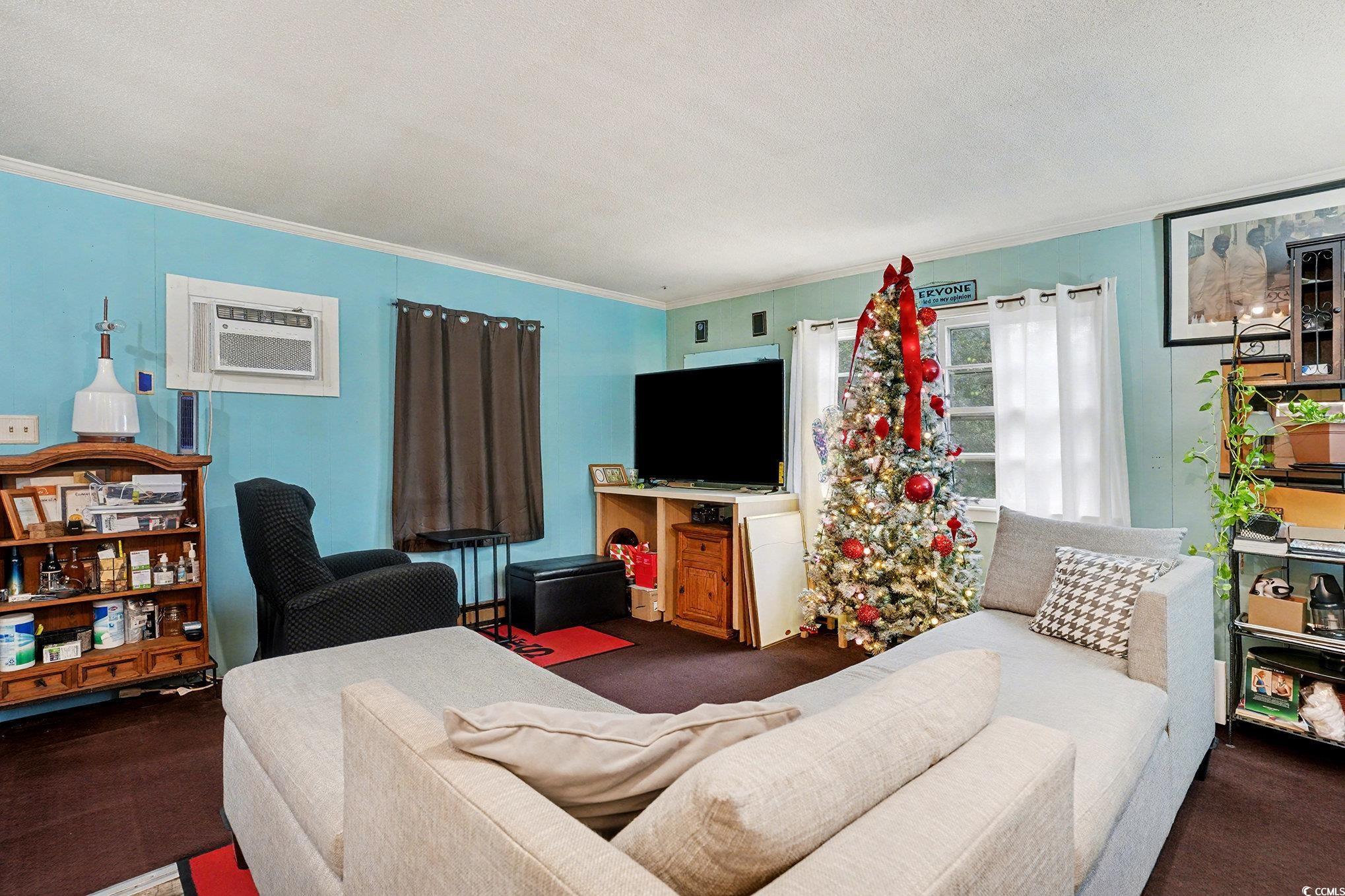 603 Maple Street Myrtle Beach, SC 29577 - Photo 18 of 40 Living area with crown molding, carpet flooring, a wall mounted AC, and a textured ceiling