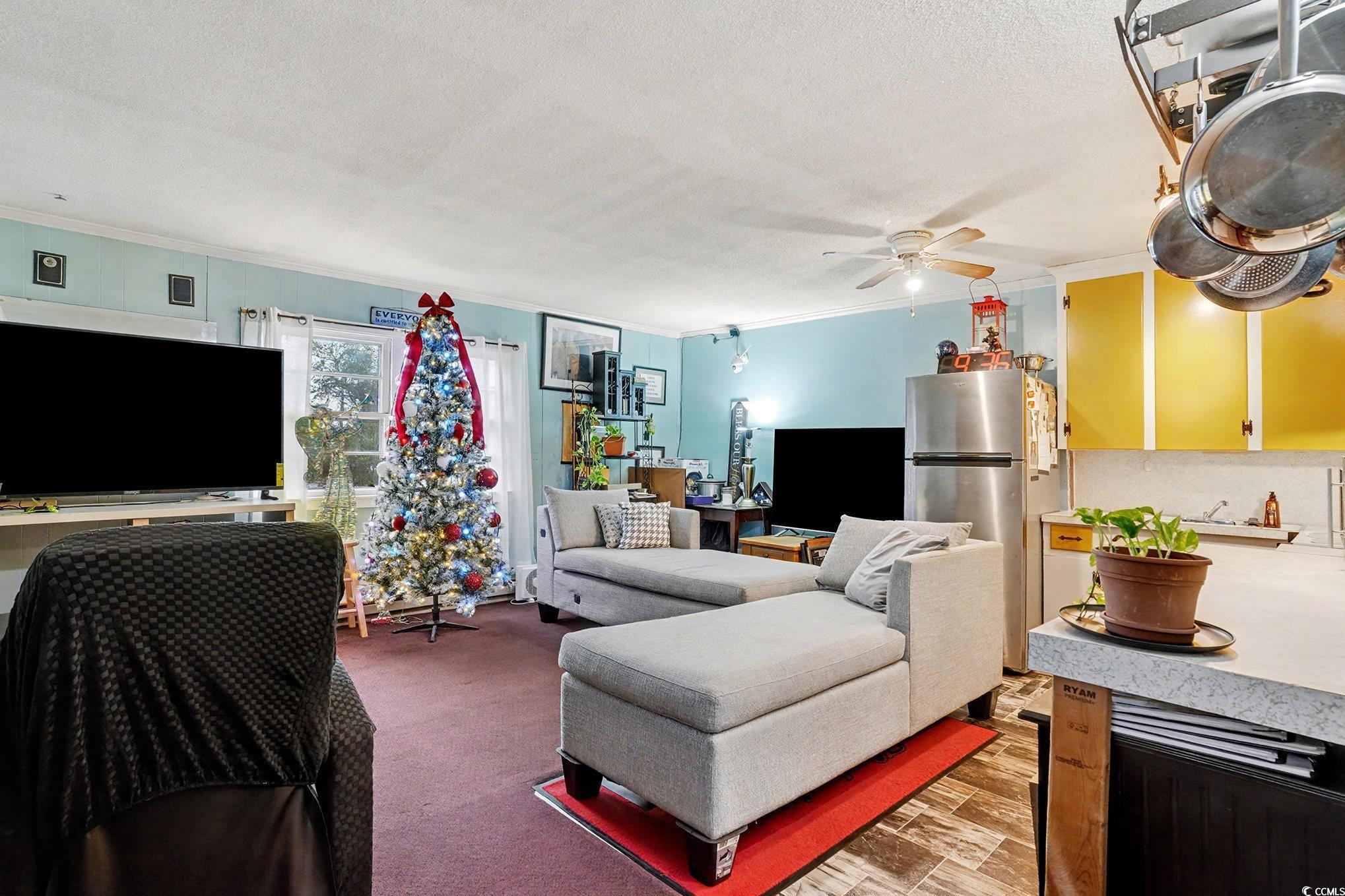 603 Maple Street Myrtle Beach, SC 29577 - Photo 19 of 40 Living area featuring crown molding, a textured ceiling, and ceiling fan