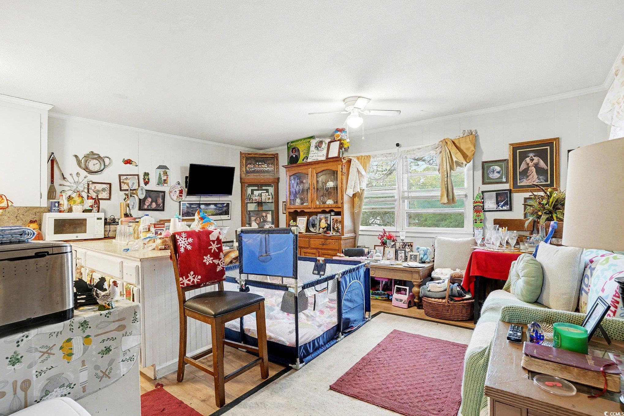 603 Maple Street Myrtle Beach, SC 29577 - Photo 27 of 40 Living area featuring crown molding, ceiling fan, and light wood-type flooring
