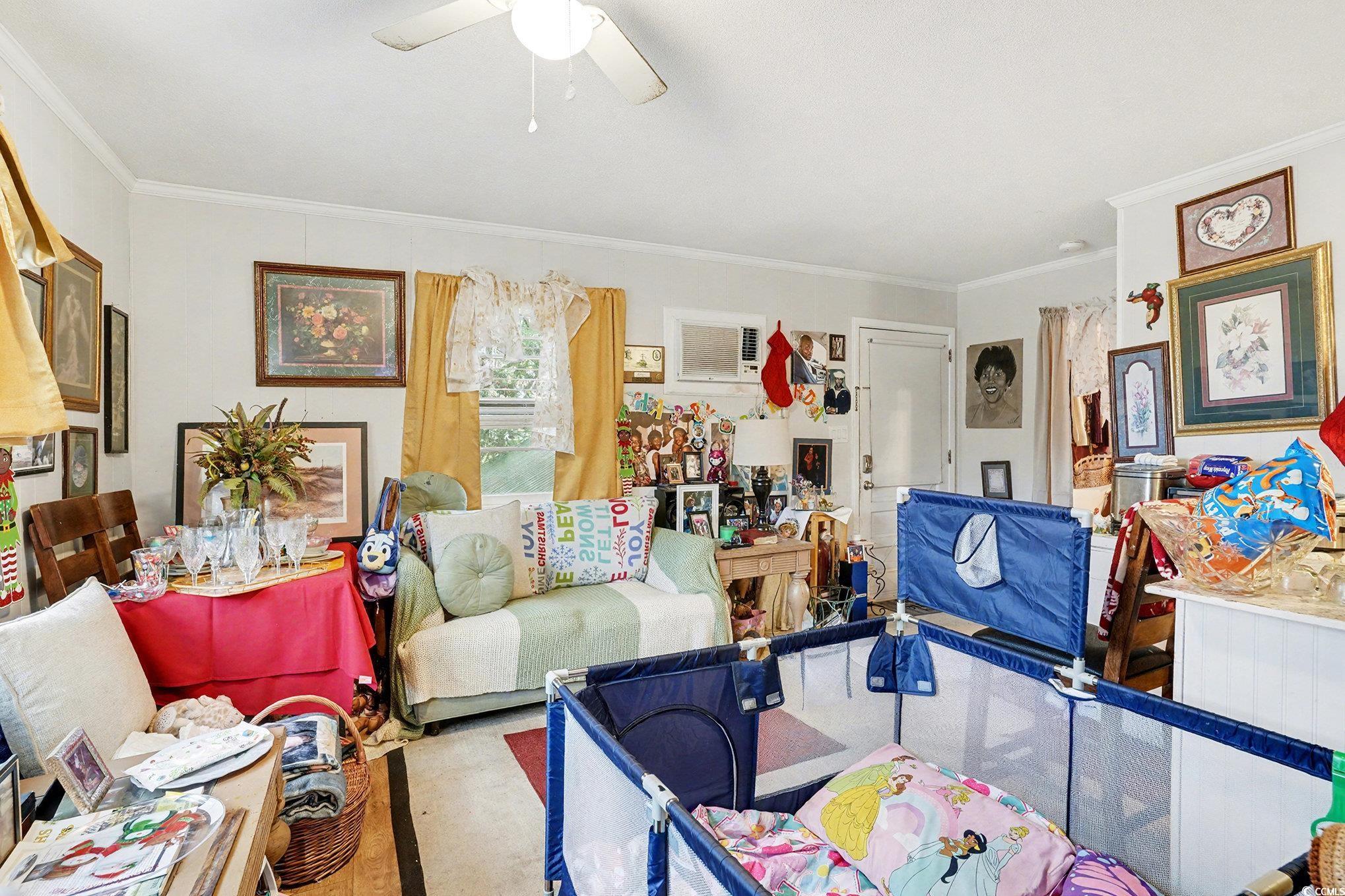 603 Maple Street Myrtle Beach, SC 29577 - Photo 29 of 40 Carpeted living room with crown molding, a ceiling fan, and a wall mounted AC
