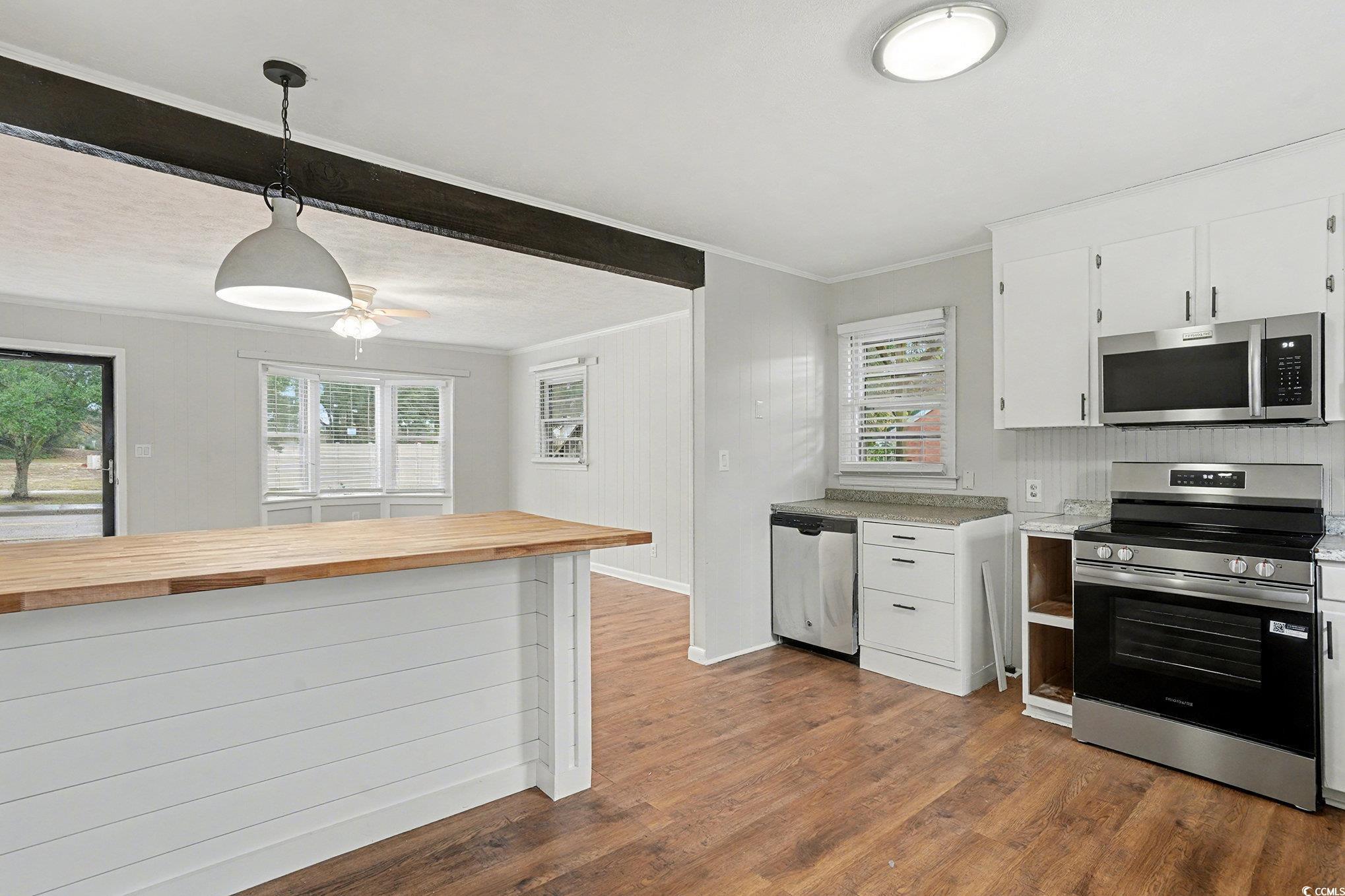 603 Maple Street Myrtle Beach, SC 29577 - Photo 10 of 40 Kitchen featuring appliances with stainless steel finishes, white cabinets, decorative light fixtures, butcher block counters, and crown molding