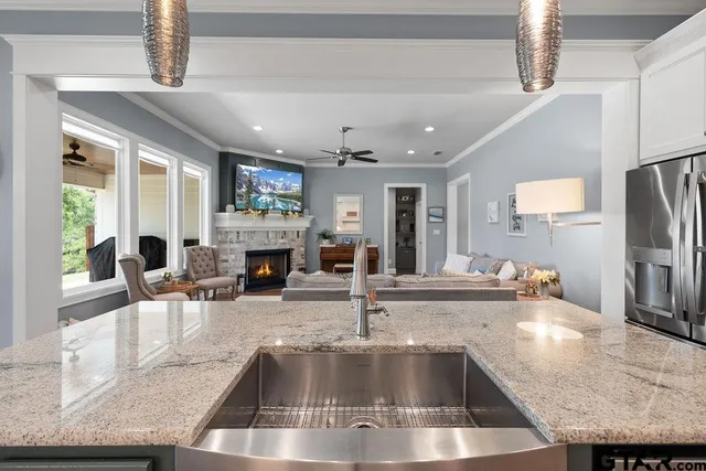 a kitchen with kitchen island a large counter top space a sink stainless steel appliances and cabinets