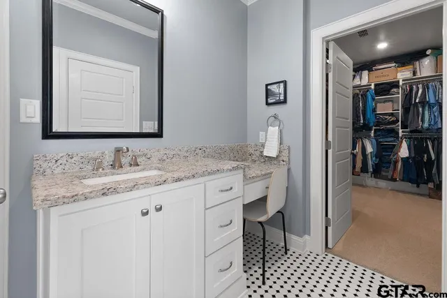 a bathroom with a granite countertop sink a toilet and a mirror