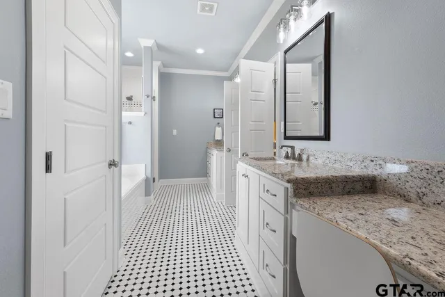 a spacious bathroom with a granite countertop sink a mirror and a shower