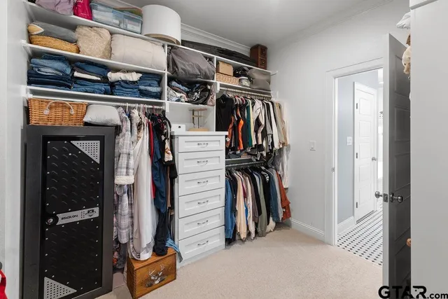 a view of walk in closet with clothes and shoes
