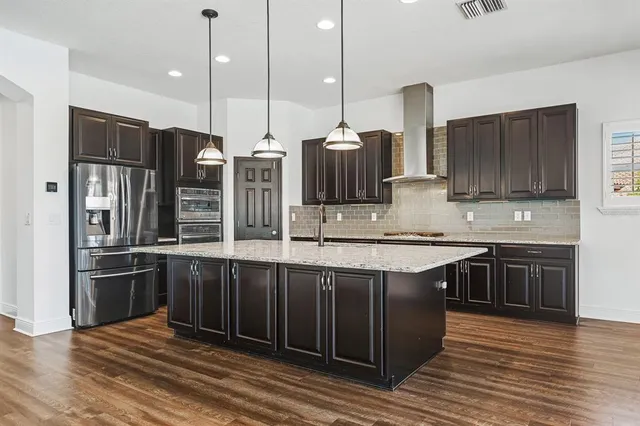 a living room with furniture kitchen view and a wooden floor