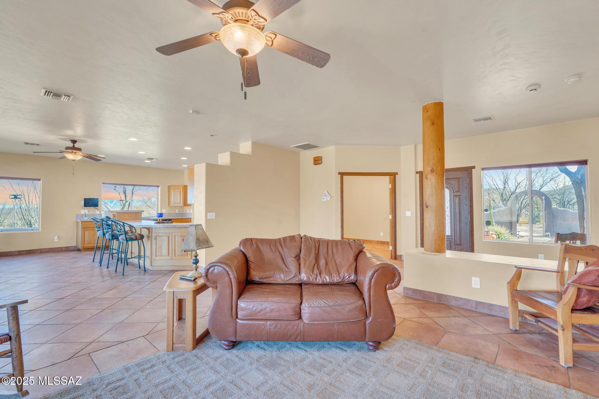1794 Oahu Court Rio Rico, AZ 85648 - Photo 19 of 48 a living room with furniture a large window and a chandelier