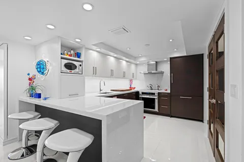 a kitchen with a sink a stove a refrigerator and a stove with wooden floor