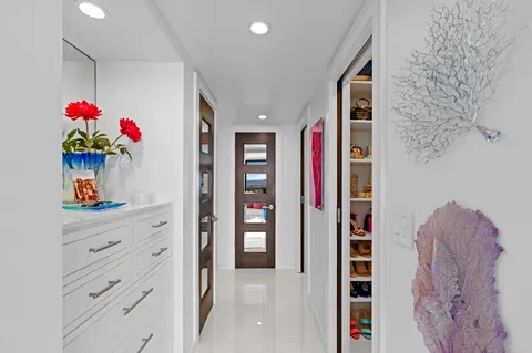 a view of hallway with a flower pot and a bookshelf