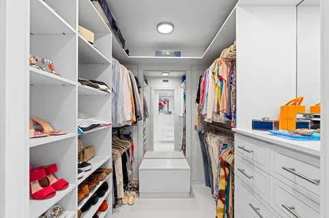 a view of walk in closet with clothes and shoes