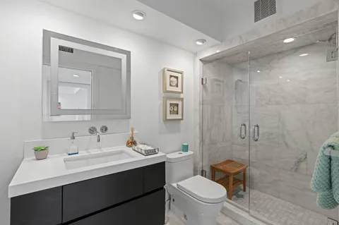a bathroom with a toilet sink double vanity and mirror