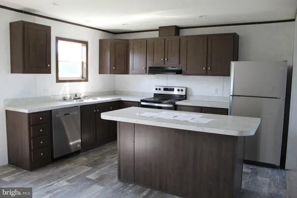 a kitchen with a sink a stove a refrigerator a center island and a window