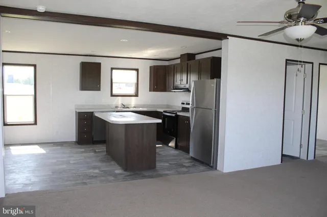 a kitchen with stainless steel appliances granite countertop a refrigerator a sink and a stove