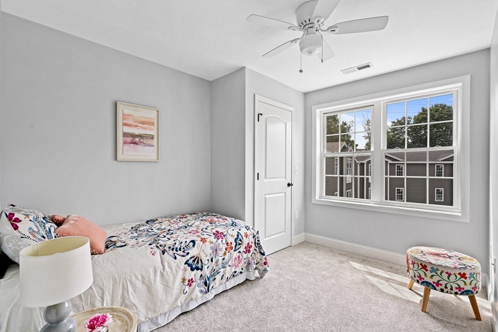 543 Andover Street, Unit 6 Lawrence, MA 01843 - Photo 17 of 27 a bedroom with a bed and a chandelier