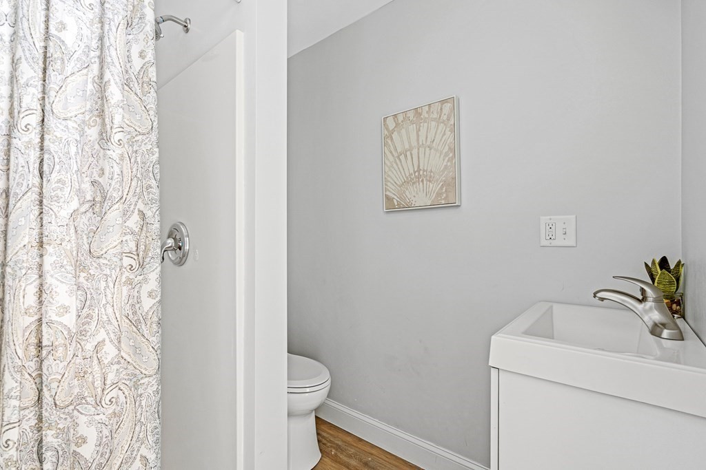 543 Andover Street, Unit 6 Lawrence, MA 01843 - Photo 22 of 27 a bathroom with a toilet and a shower curtain