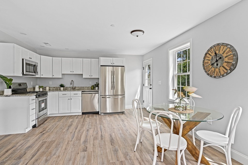 543 Andover Street, Unit 6 Lawrence, MA 01843 - Photo 6 of 27 a kitchen with white cabinets and stainless steel appliances