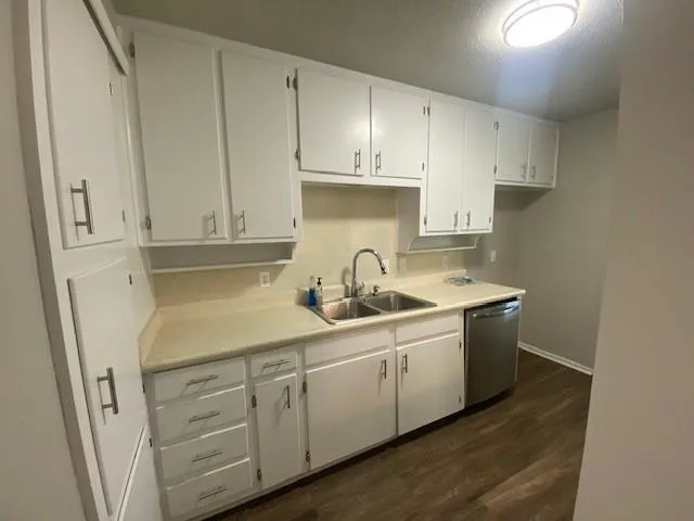 a view of a sink and cabinets with wooden floor