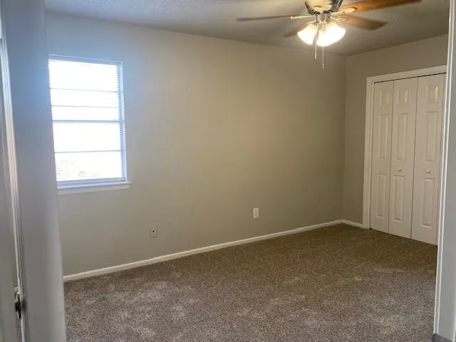 an empty room with a chandelier fan