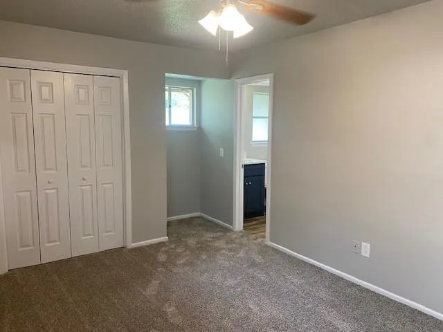an empty room with windows and closet