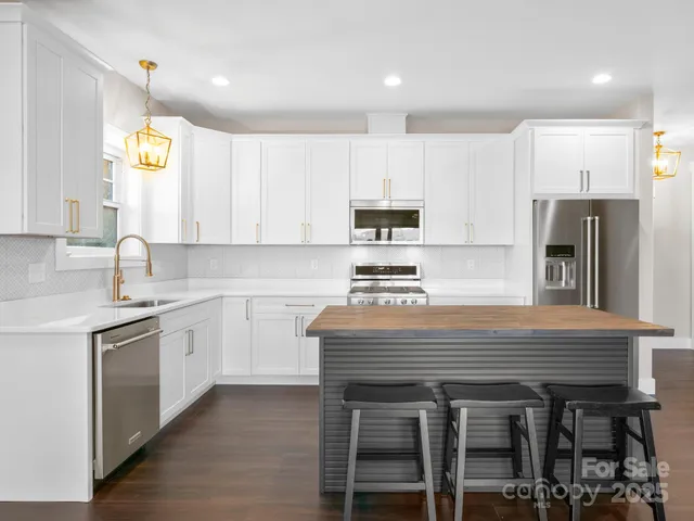 a kitchen with kitchen island a sink stainless steel appliances and cabinets