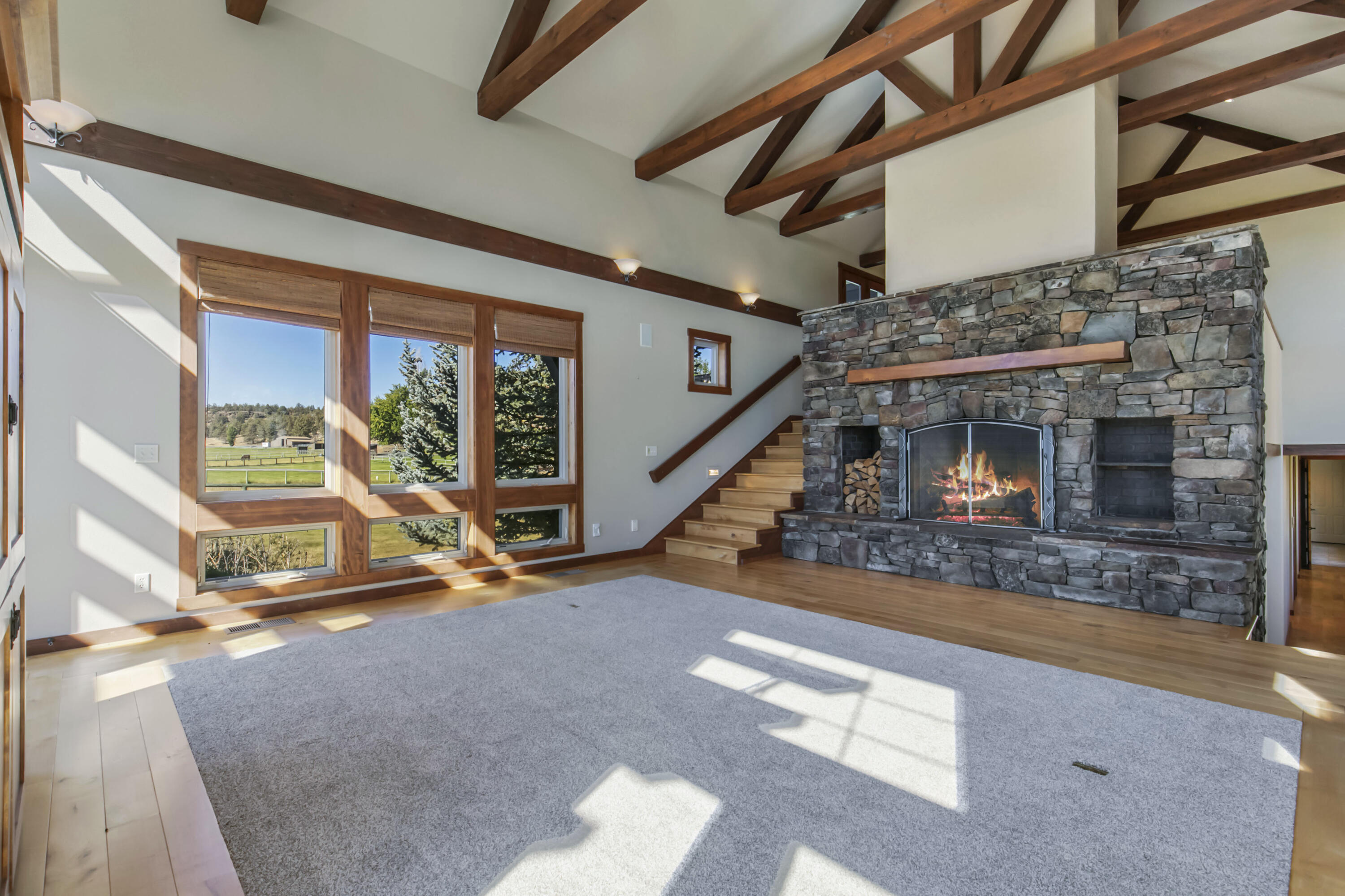 19460 Dayton Road Bend, OR 97703 - Photo 4 of 34 a view of an empty room with wooden floor a fireplace and a window
