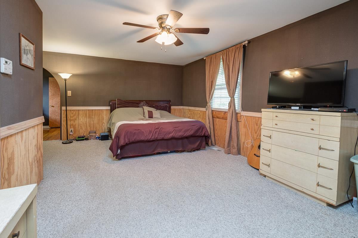 7187 Bahne Road Fairview, TN 37062 - Photo 18 of 30 a spacious bedroom with a bed and a flat screen tv