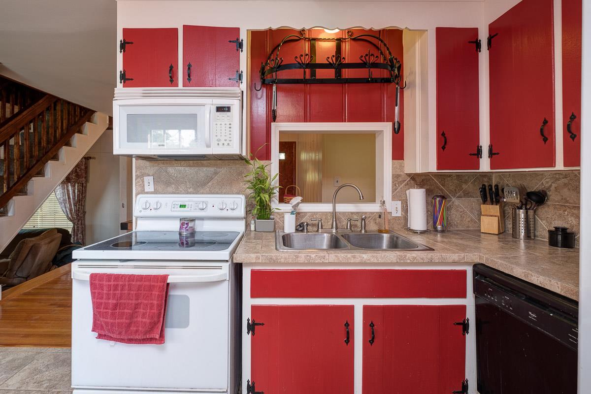7187 Bahne Road Fairview, TN 37062 - Photo 10 of 30 a kitchen with stainless steel appliances a sink stove and cabinets
