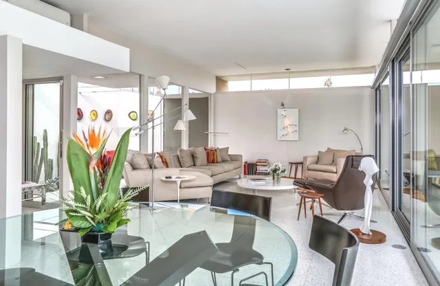a dining room with furniture potted plants and wooden floor