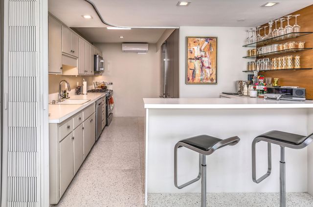 a kitchen with stainless steel appliances granite countertop a sink a stove and a refrigerator