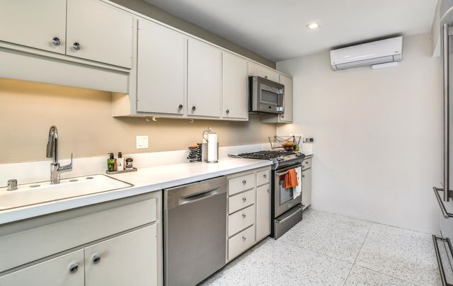 a kitchen with stainless steel appliances granite countertop a stove a sink and a refrigerator