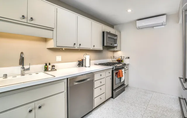 a kitchen with stainless steel appliances granite countertop a stove a sink and a refrigerator