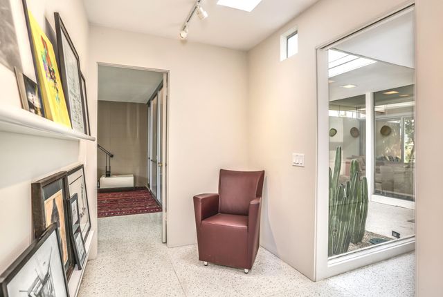 a view of a bedroom with furniture and large windows