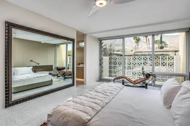 a bedroom with a bed and a lamp with the wooden floor