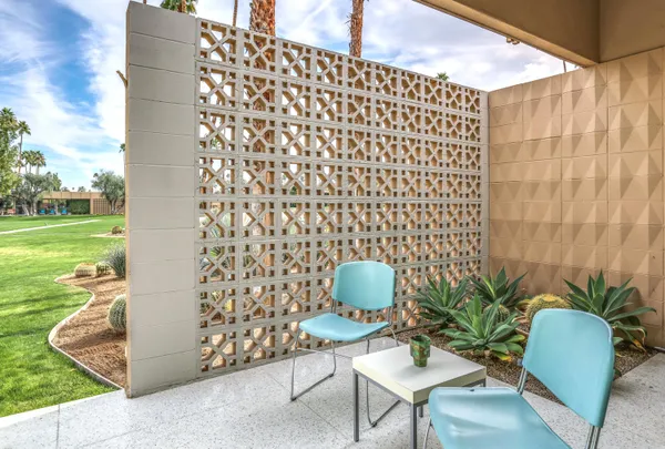 a view of a patio with table and chairs potted plants and big yard
