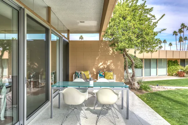 a view of a patio with a table chairs and a backyard
