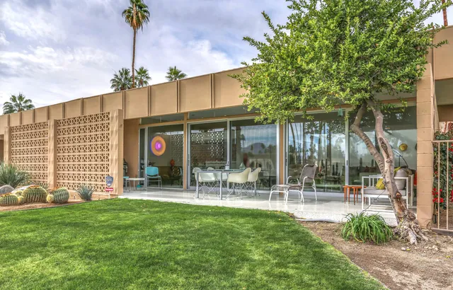 a backyard of a house with table and chairs