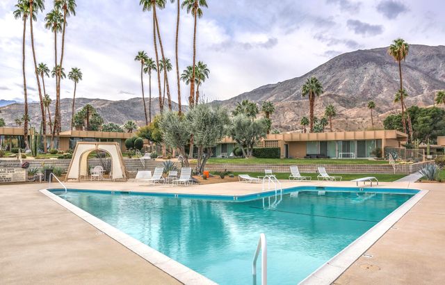 a view of a house with pool and a yard